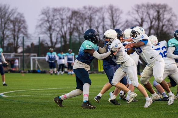 Students playing american football in a varsity match